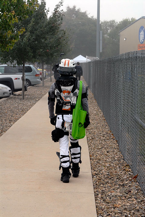 Armed with his Wildcat Comic Con tote bag, a Titan Pilot strides confidently toward the Field House.