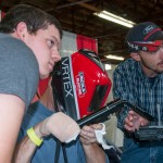 Welding students Daniel J. Peppernick, left, of Spring Run (welding and fabrication engineering technology) and Teague W. Ohl, of Cogan Station (welding technology) help visitors to use a virtual reality welding simulator. 