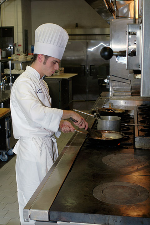 Christopher S. Kasler tends a saute pan while preparing ...