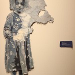 One of James Arendt's daughters is depicted in a piece titled "Harper (Firecracker)." Penny Griffin Lutz, gallery manager, embroidered the artworks'  titles on denim as an ingenious alternative to the gallery's standard printed labels. 