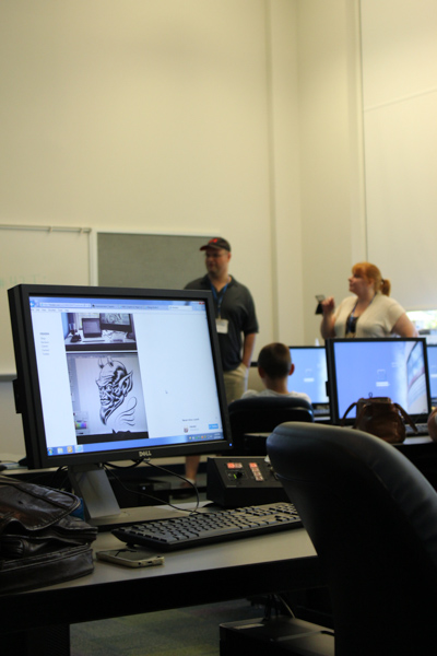 Monitors reflect the work of webcomic creators Thom and Kambrea Pratt, sharing their digital world at Comic Con for the third year.