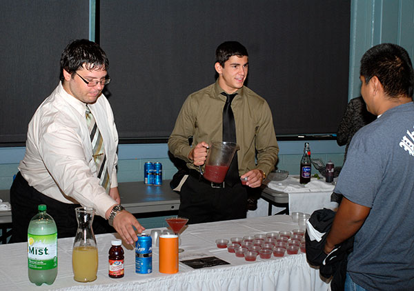 Randall C. Janowitz, a culinary arts and systems major from Westminster, Maryland, pours samples of the Maroon Dragon, co-created with Patrick N. Goldy (left), a hospitality management student from Williamsport.