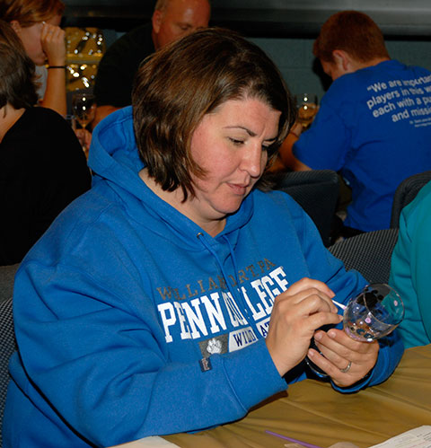 Shelly Marshall, of Pottstown (whose daughter, Justene A., is enrolled in the business administration: management concentration), exhibits a steady hand and calm concentration as she hand-paints a Penn College-themed wine glass.