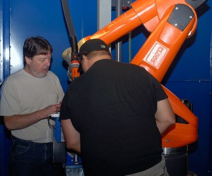 Dan Flicek (left), programming supervisor for CLOOS Robotic Welding Inc. in Schaumburg, Ill., trains Penn College welding instructor Aaron E. Biddle ...