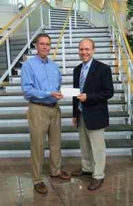 Brian M. Fuhrman, left, major account manager for Waste Management Inc., delivers a donation to Robb Dietrich, executive director of the Penn College Foundation. 