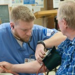 Student Alex S. Bogler, of South Williamsport, checks a senior’s blood pressure as part of the health-screening clinic.