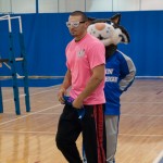 Mascot and friend engage in a dance-off during a break in the volleyball action.