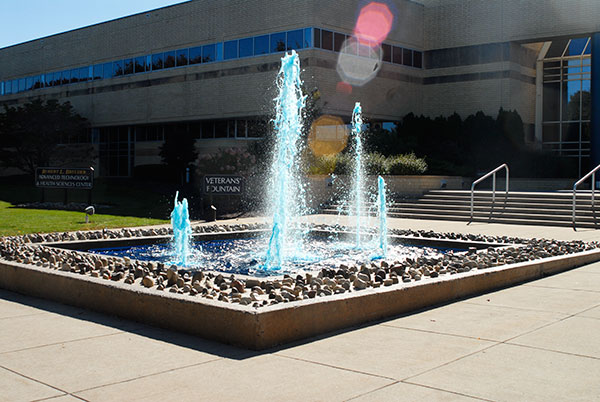 Sunlight dances off the prancing waters of the Veterans' Fountain, dyed Wildcat Blue for the Homecoming celebration.