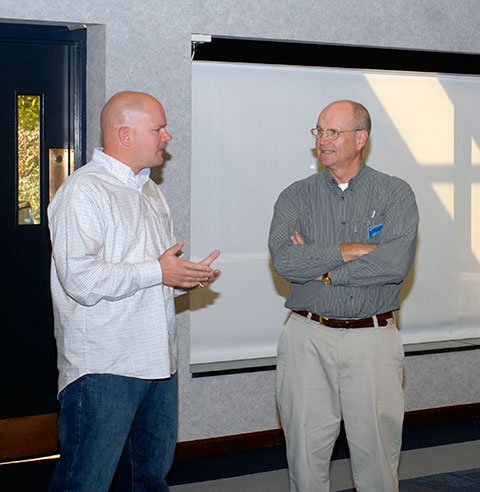 Kyle A. Oliver (left), who attended the construction reunion with his wife and two young sons, talks with Barry J. Stiger, vice president for institutional advancement. Oliver earned Penn College degrees in building construction technology (1998) and residential construction technology and management (2008).