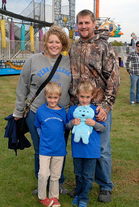 Stopping for a quick photo in the midst of food, rides and games are Disability Services' Sarah S. Moore; her husband, Joshua; and sons Colin (left) and Liam.