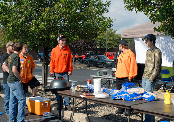 Members of the Diesel Performance Club staff a hot-dog grill, a concession fundraiser for the organization and the Wounded Warrior Project.