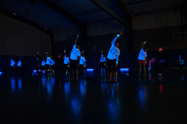 Participants in the benefit Glow Run cool down – and light up – in the Field House.