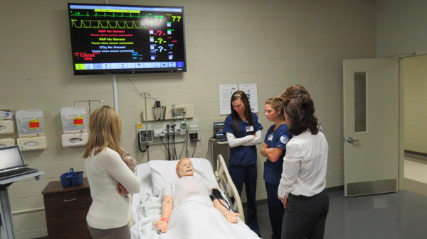 Nursing faculty members and students show a prospect the high-tech workings of SimMan.