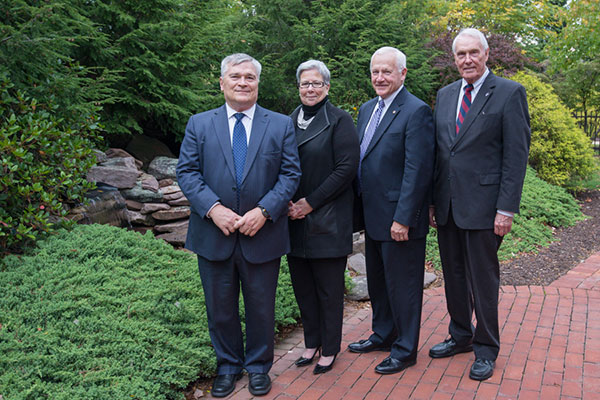 Penn State President Eric J. Barron (left) is joined on the verdant grounds of the Victorian House by (from right) Robert E. Dunham, chairman emeritus of the Penn College Board of Directors; state Sen. Gene Yaw, current board chairman; and Penn College President Davie Jane Gilmour.