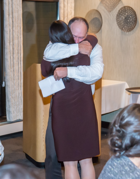 A Hall of Fame inductee for softball, Lisa Miller is warmly hugged by Roger Harris, her coach for three seasons.