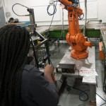 A Williamsport Area Middle School eighth-grader handles the controls of an industrial robot.