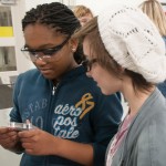 Middle-schoolers take a close look at a CNC-machined wrench before watching the process.