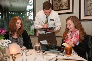 S. Jordan Stammer, center, a student in Penn College’s culinary arts technology major, takes the dinner order of Anita K. Fink, left, and Katharina M. Sutter, both exchange students from Fachhochschule Vorarlberg in Dornbirn, Austria, during a Classical Cuisines of the World dinner in the college’s Le Jeune Chef Restaurant. The meal featured foods from the Alsace region of France, just a few hours from the students’ home university.