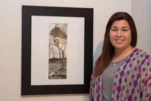 Ronni N. Warner, winner of the People's Choice award for "100 Works! - The Centennial Exhibit," stands next to her winning entry, "Past, Present, Future," a blend of three digital photographs, in The Gallery at Penn College. 
