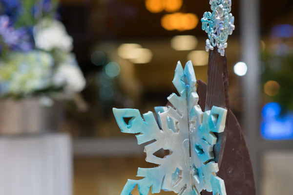 Befitting the season, widely sprinkled blue snowflakes adorn a large, chocolate sculpture … 