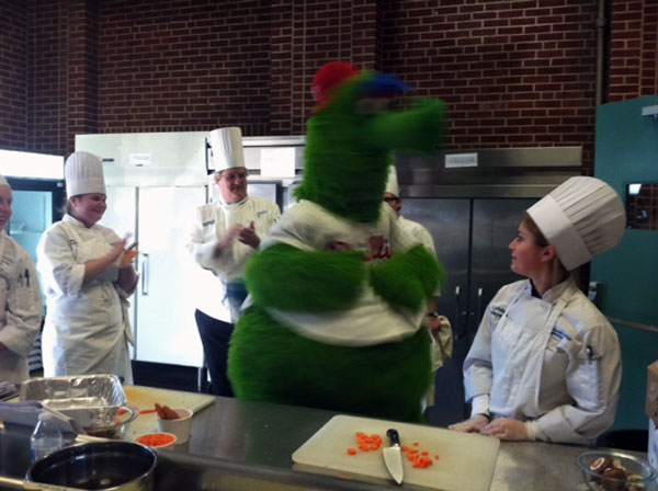 Sharing the kitchen with the Phillie Phanatic are, from left, culinary arts technology major Katelynn M. Watson, of Milton; Jessica N. Felton, of State College; Chef Paul E. Mach, assistant professor of hospitality management/culinary arts; and Lyndsay E. Maynard, of Fleetwood. Felton and Maynard are culinary arts and systems students.