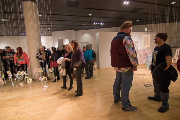 Attendees at the gallery reception suspend reality while mingling amid the artist's thread-borne reimaginings.