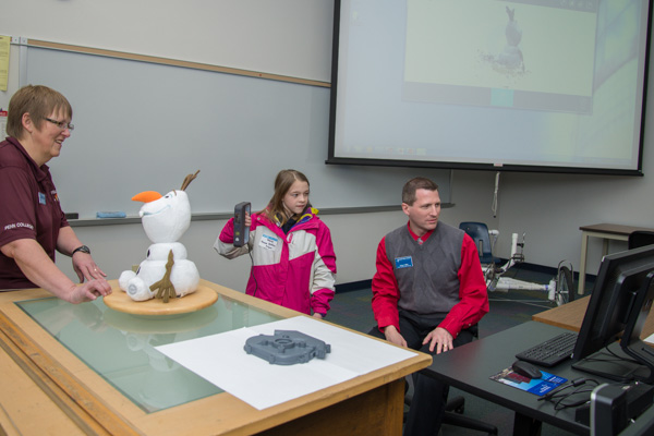 Faculty members Katherine A. Walker and Craig A. Miller assist a young visitor in 3D-scanning Olaf, the famous 