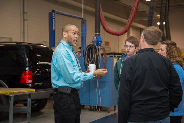 Automotive instructor Eric D. Pruden converses with a family.