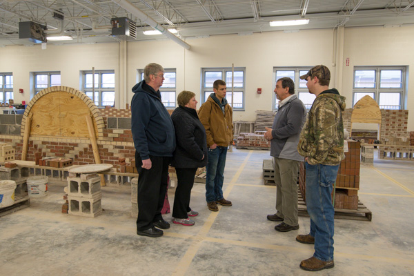 … where instructor Glenn R. Luse and Lee D. Bouton (far right), a buiding construction technology: masonry concentration senior from Stillman Valley, Ill., talk shop with visitors. 