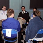 Mark A. Trueman (center), director of paramedic technology programs at the college, follows the flowing conversation.