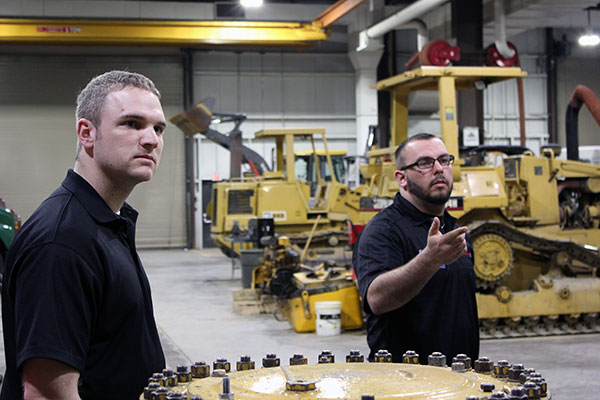 Diesel technology grads Eric F. Faust (left), Class of 2009, and John D. Motto, '11, lead a tour of their former ESC labs. Motto, a diagnostic technician with the Penn Power Group in Muncy, services machinery for Faust, an equipment foreman with Halliburton.