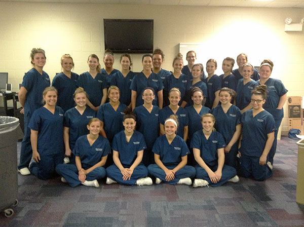 Professionally garbed and enthusiastically on-duty, students in Penn College's Dental Hygiene program assemble for a Sealant Saturday team photo.