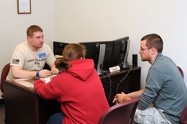 Veterans Affairs Work-Study employee Jacob M. Heuman, a building automation technology major from Boiling Springs, talks with a couple about their military education benefits.