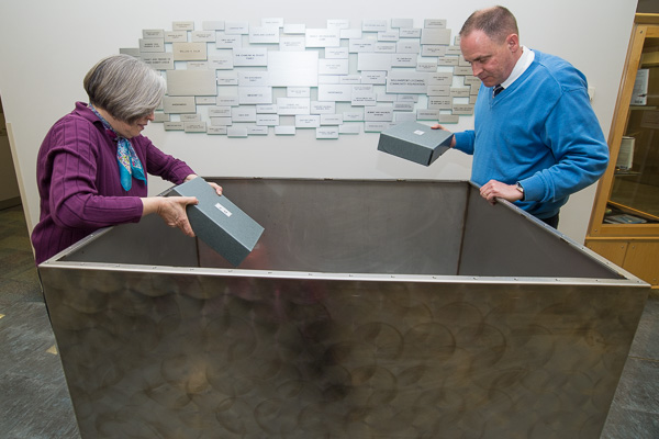 Librarian Patricia A. Scott and Nathan D. Smyth, assistant dean of industrial, computing and engineering technologies – members of the Time Capsule Committee – load the stainless steel box.