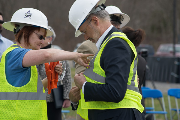Diane H. Bubb, ShaleNET U.S. case manager, dresses the governor in safety gear before he climbs atop the rig.