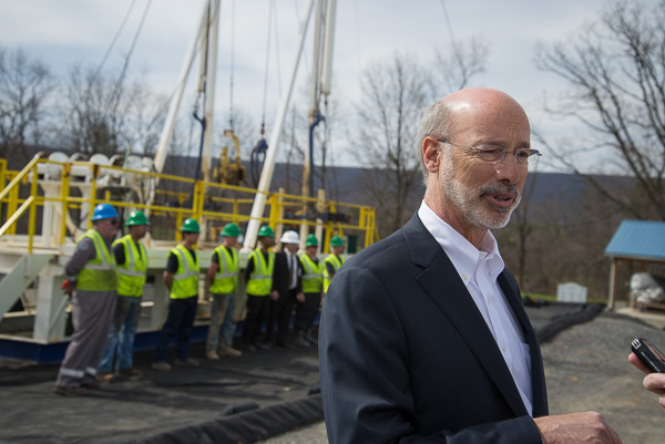 The governor obliges a journalist while the rig team poses for photos.