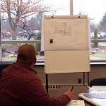 A student "sells" his landscape design to judges Nicholas B. Cramer and Melissa D. Berrier-Cramer.