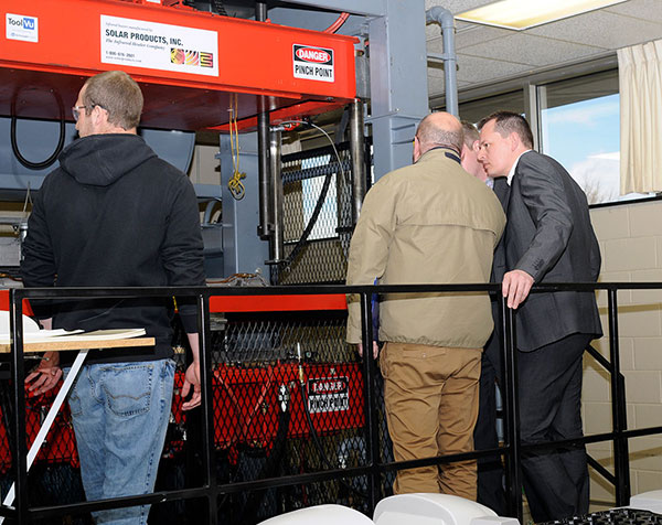 Guests ascend the thermoformer, operated by Jared W. Mahaffey (left), a plastics and polymer engineering technology major from Linden.