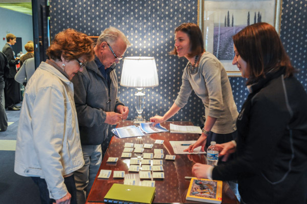 Alice and Edward Danneker, ’56, sheet metal, are checked in by Becky J. Shaner, ’03, alumni relations specialist, and Valerie L. Fessler, annual giving manager. 