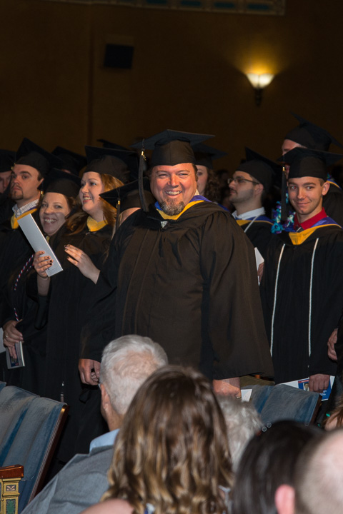 A faculty member enjoying the student side of commencement, welding lecturer Matthew W. Nolan smiles to his family. Nolan, who already holds degrees in welding (1987) and occupational therapy <br />
<br />
assistant (1996), added a bachelor's in technology management Friday.
