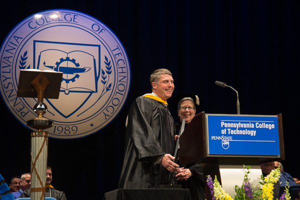 The president congratulates faculty honoree John G. Upcraft, instructor of machine tool technology/automated manufacturing, a popular mentor to the SAE Baja team and the first recipient of a bachelor's degree from Penn College.