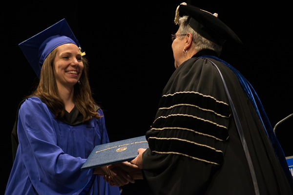 A diploma is presented to Sarah E. Boyer, a dental hygiene: health policy and administration concentration student from Great Mills, Maryland, who also received the Patricia L. Saxton Excellence in Dental Hygiene Award. The award is presented in recognition of President Gilmour's mother, who died March 28.