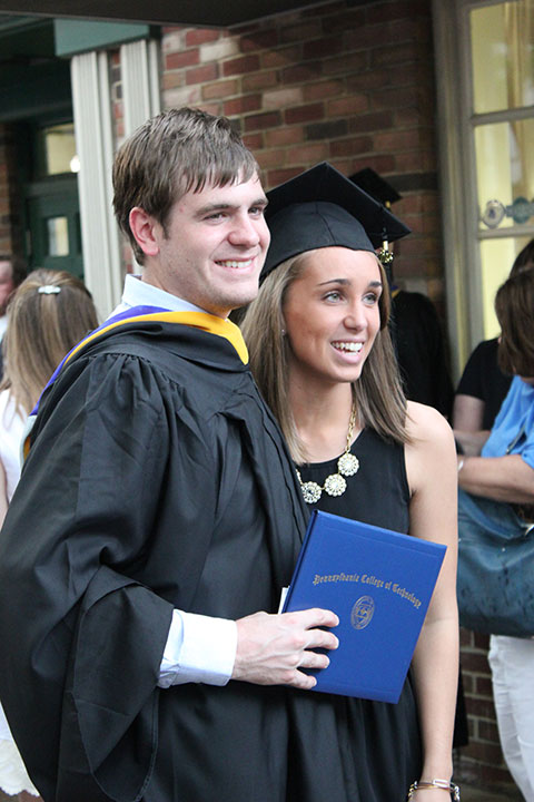 One of the college's newest alums shares his happiness (and his graduation cap) with a friend.