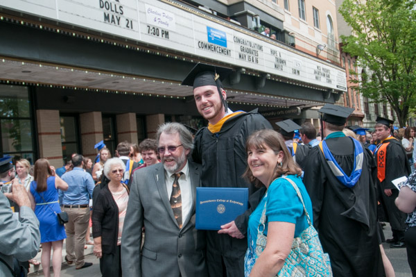 Lance R. Roan, a graduate in information technology: information assurance and security concentration, poses for a photo with his proud parents.