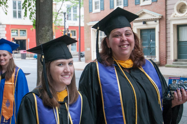 Wearing stoles from Lambda Epsilon Chi, the national paralegal honor society, a pair of grads smiles for the camera.