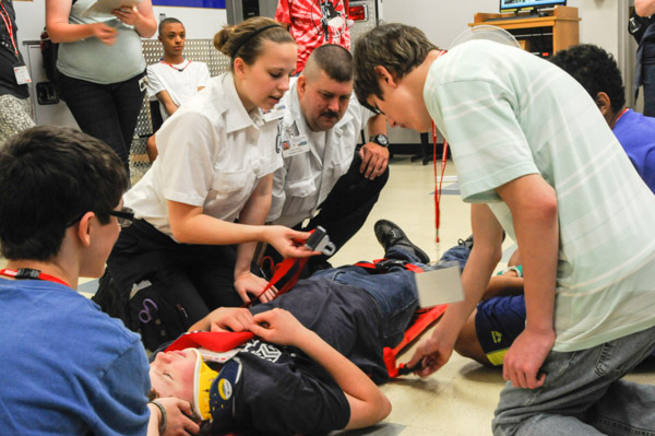 Penn College emergency medical services students lead participants in stabilizing an accident victim in order to move him from the scene.