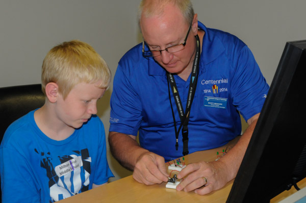 Scott D. Neuhard, assistant professor of electronics, assists a student with his circuit.