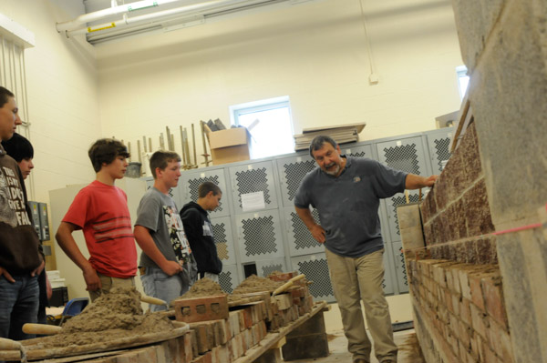 Glenn R. Luse, instructor of building construction/masonry, offers guidelines to Williamsport Area Middle School students before they “dig in” to bricks and mortar.