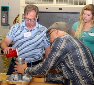 Workshop participants experience Penn College’s hands-on instruction, preparing powder for testing in the rotational molding lab. From left are Trevor Bludis, of Novatec, Baltimore; Margarito Lopez, of Total Petrochemicals USA, Deer Park, Texas; and Kimberly Kelley, of Inca Molded Products in Nashville, Tenn.