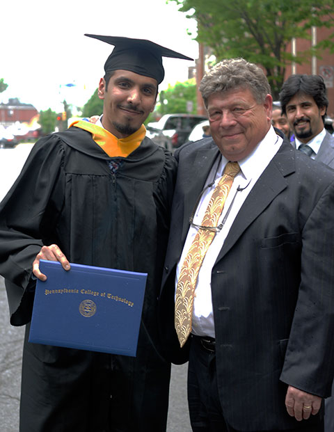 ... and is later congratulated outside by Marc E. Bridgens, school dean.